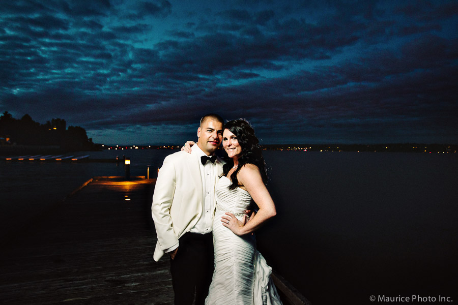 A bride and groom pose for pictures at sunset on the dock at the Seattle Tennis Club